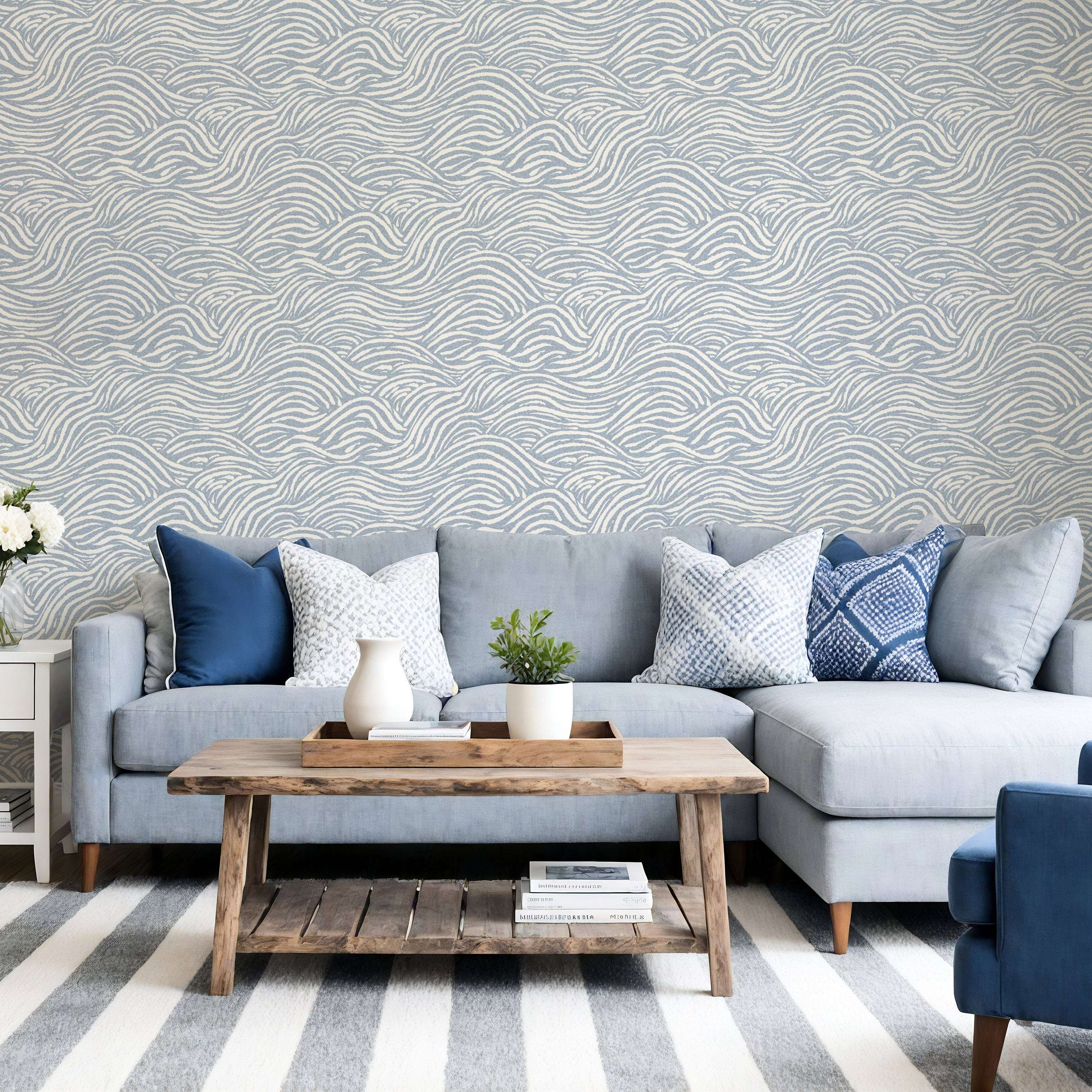light blue coastal waves wallpaper on wall with light blue wavy lines behind a sofa