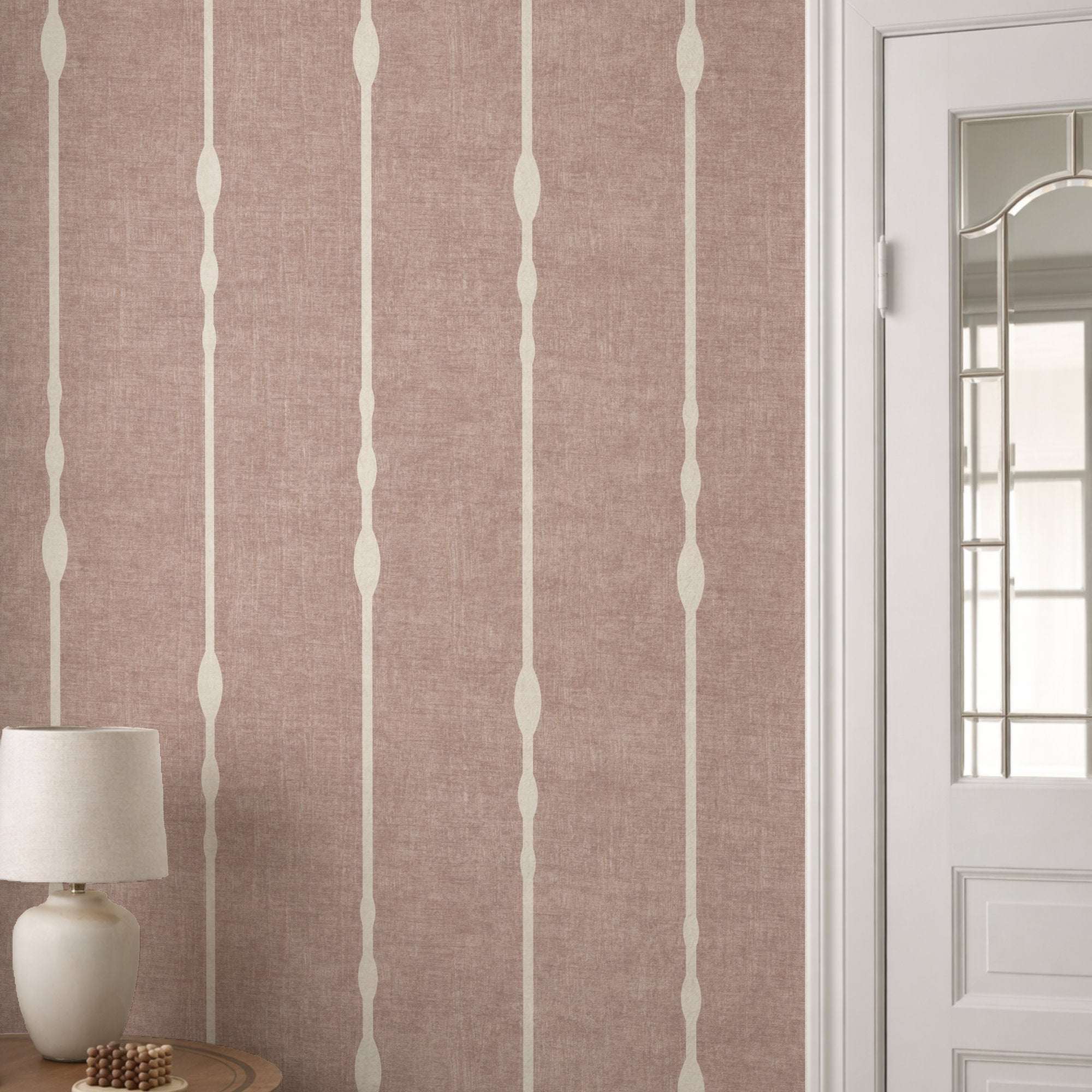 Vertical striped wallpaper with beaded stripe motif on dusty pink ground and pale vertical lines