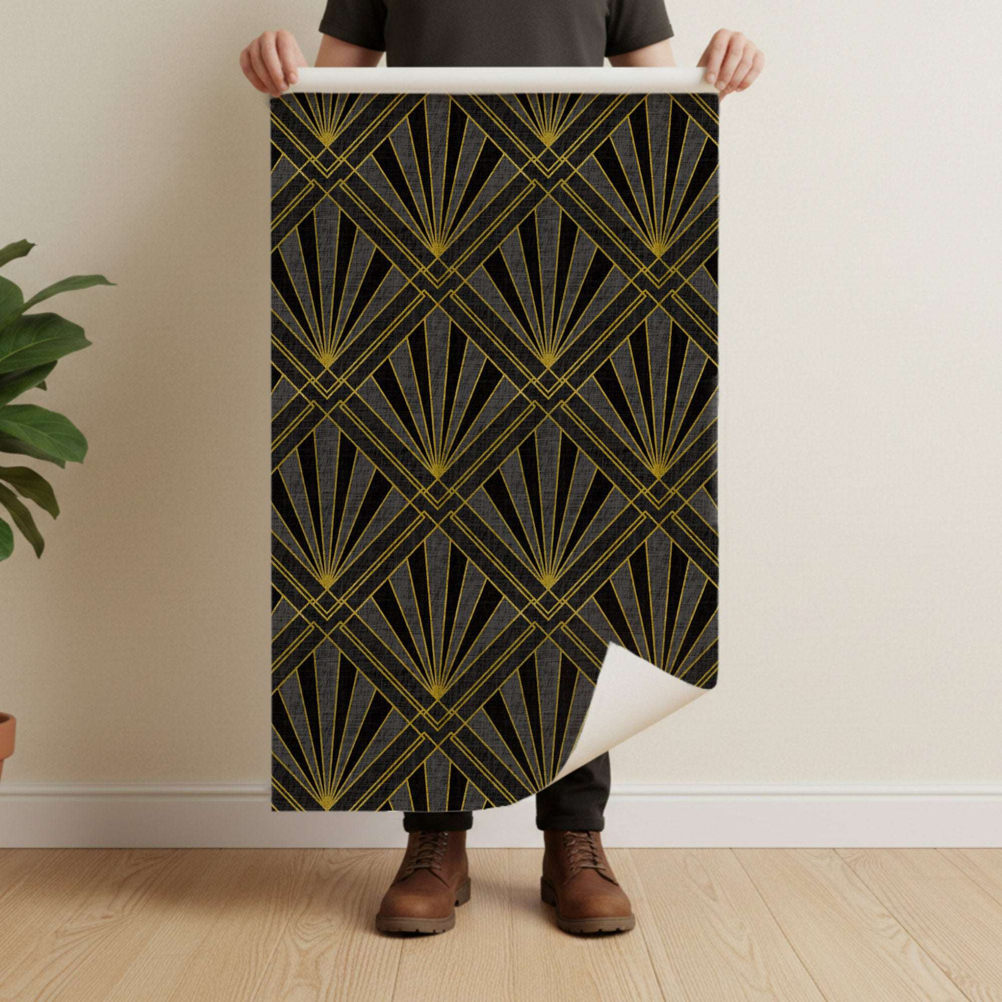 Art deco wallpaper panel held up, showing gold sunburst rays and diamond lattice on dark base