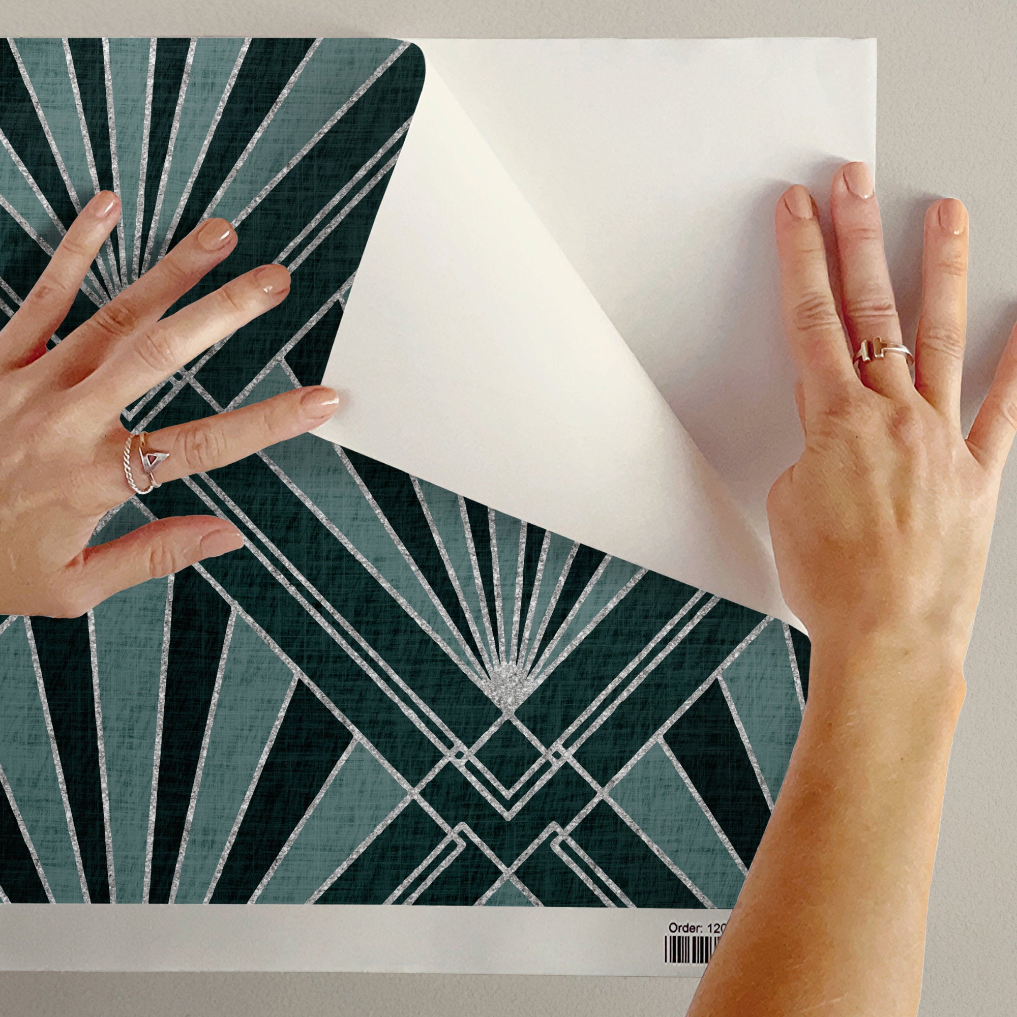 Peel-and-stick geometric wallpaper section with teal sunburst fan-diamond pattern