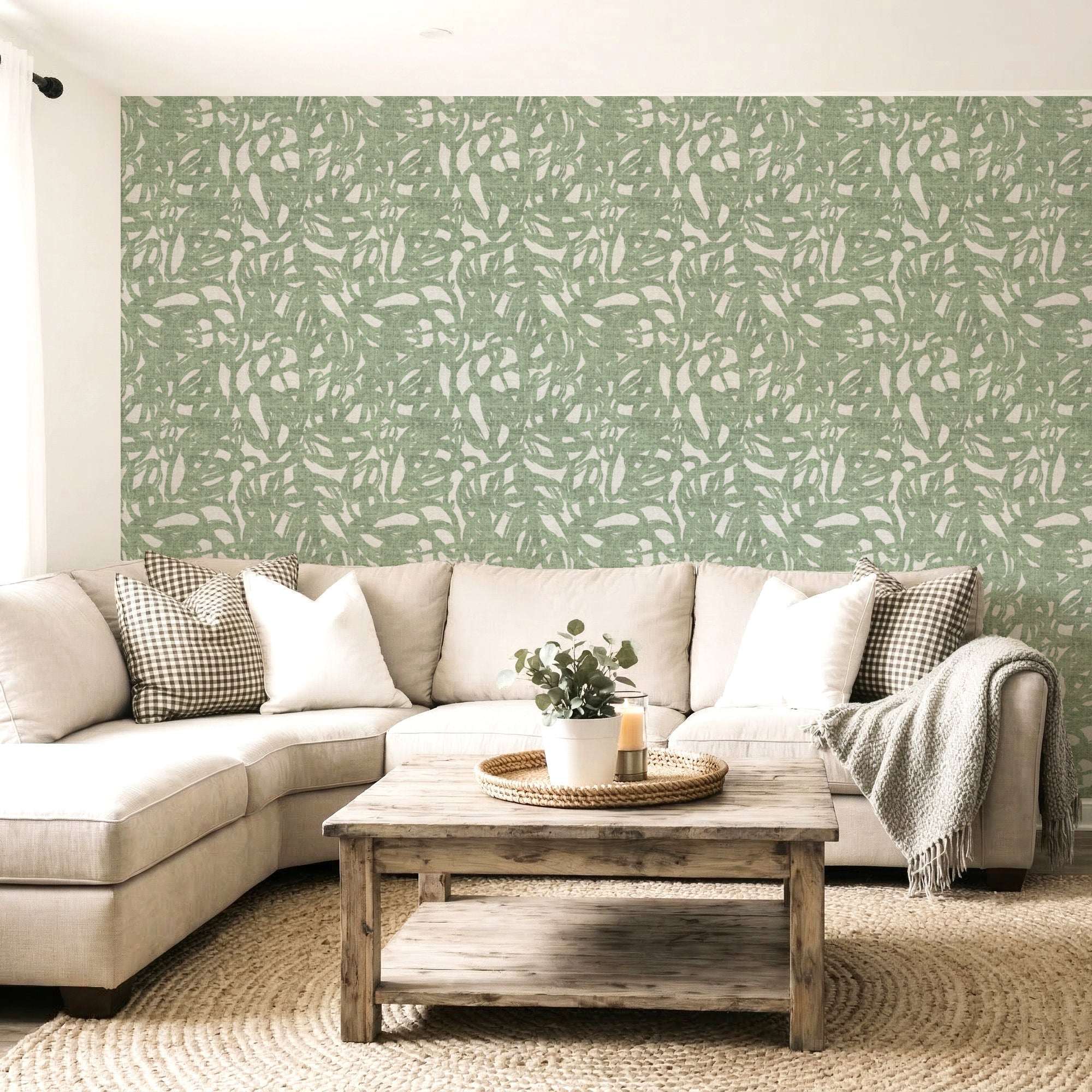 Green abstract brushstroke wallpaper covering wall behind a light sofa