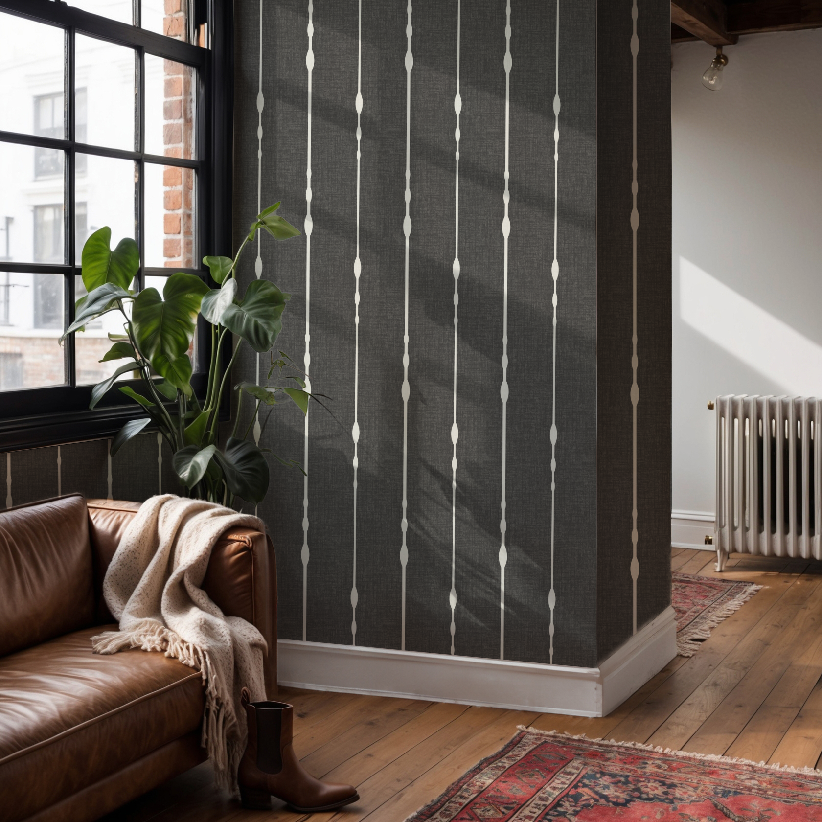 Black and white vertical stripe wallpaper on two corner walls in an open-plan apartment with wood floors