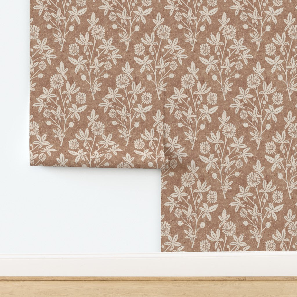 Close-up wall view of tan block print wallpaper with repeating floral and geometric diamond design.