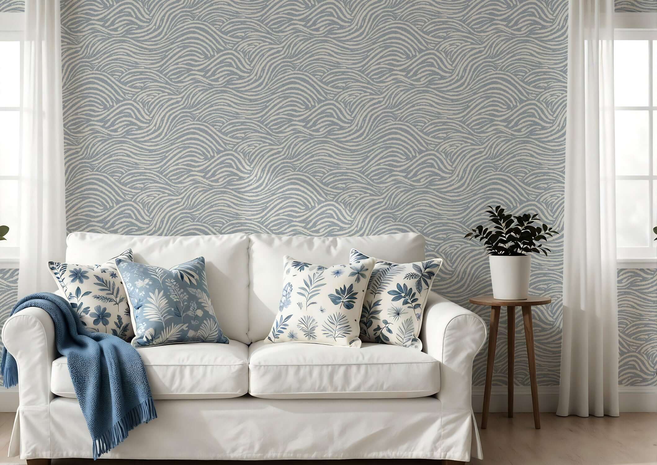 White sofa with decorative pillows against a patterned wall featuring coastal waves wallpaper in a living room setting.