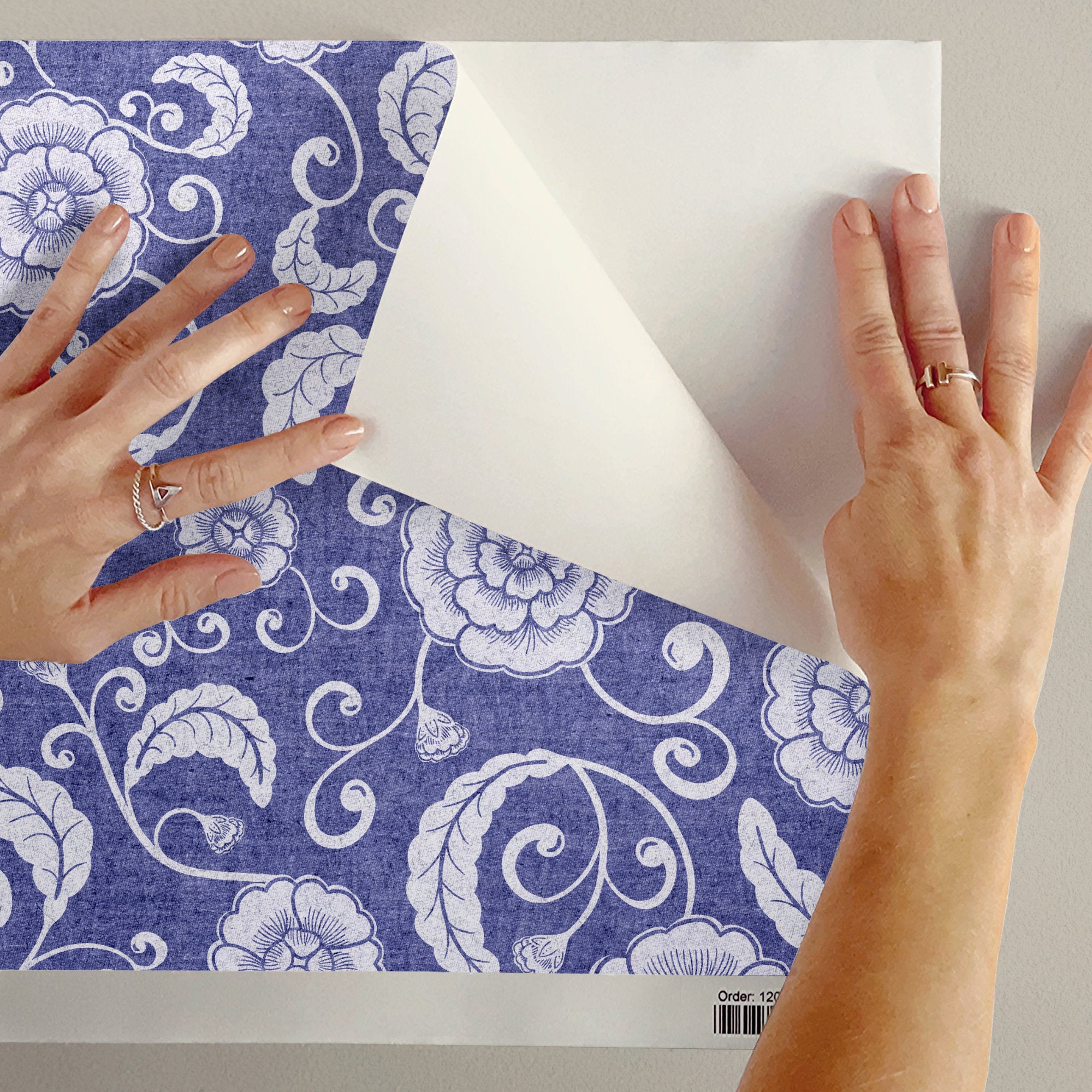 Peeling back blue ginger jar wallpaper to show the removable peel and stick finish