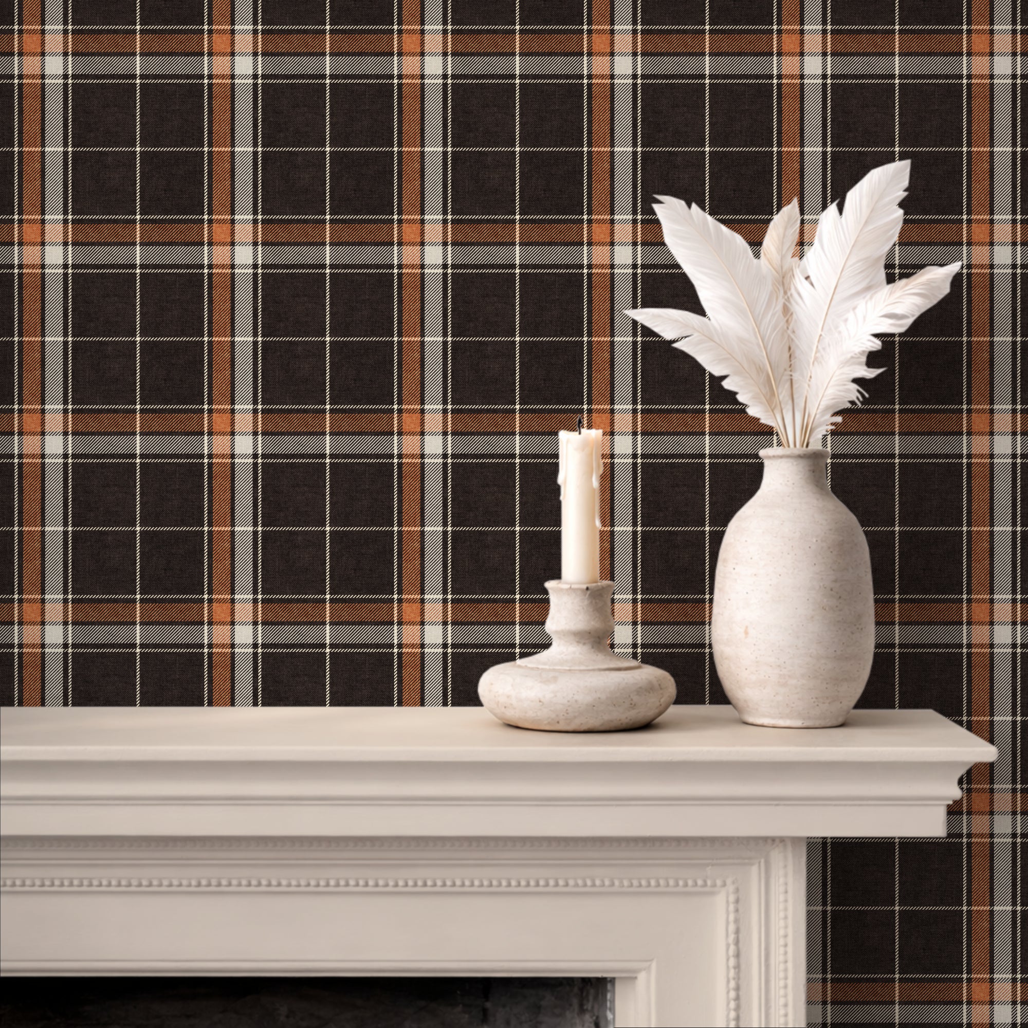 Brown and orange heritage plaid wallpaper displayed behind a white mantel with a candle holder and a vase of white feathers.