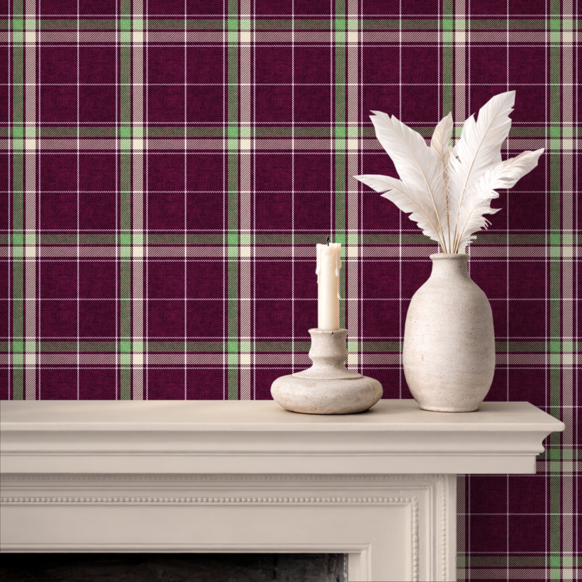 Plum and green heritage plaid wallpaper displayed behind a white mantel with a candle holder and a vase of white feathers.