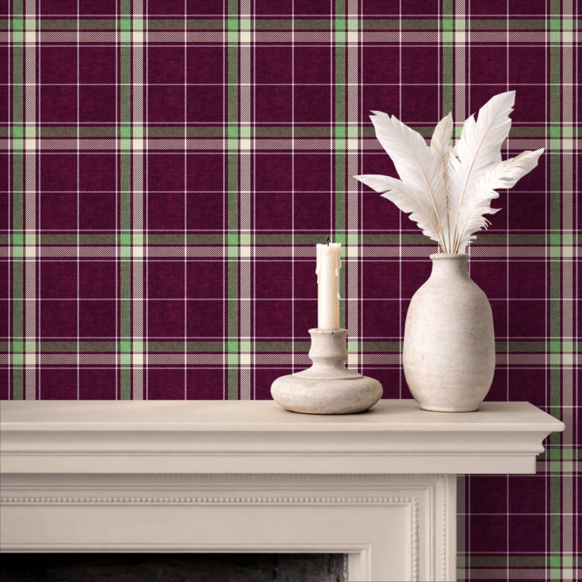 Plum and green heritage plaid wallpaper displayed behind a white mantel with a candle holder and a vase of white feathers.
