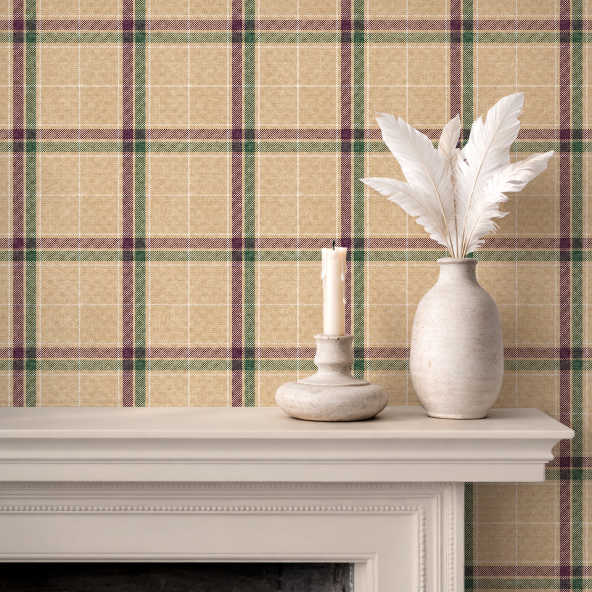 A styled interior scene showing a beige heritage plaid wallpaper pattern behind a white mantelpiece, with a white vase holding white feathers and a white candle holder with a lit candle on the mantel.