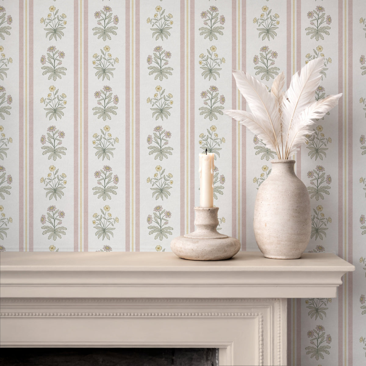 Pink floral stripe wallpaper above fireplace with candle and ceramic vase