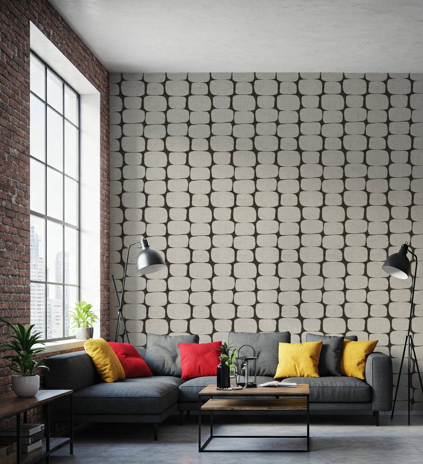 Modern clack and white geometric wallpaper in a living room with a gray sectional sofa, colorful pillows, and a textured wall.