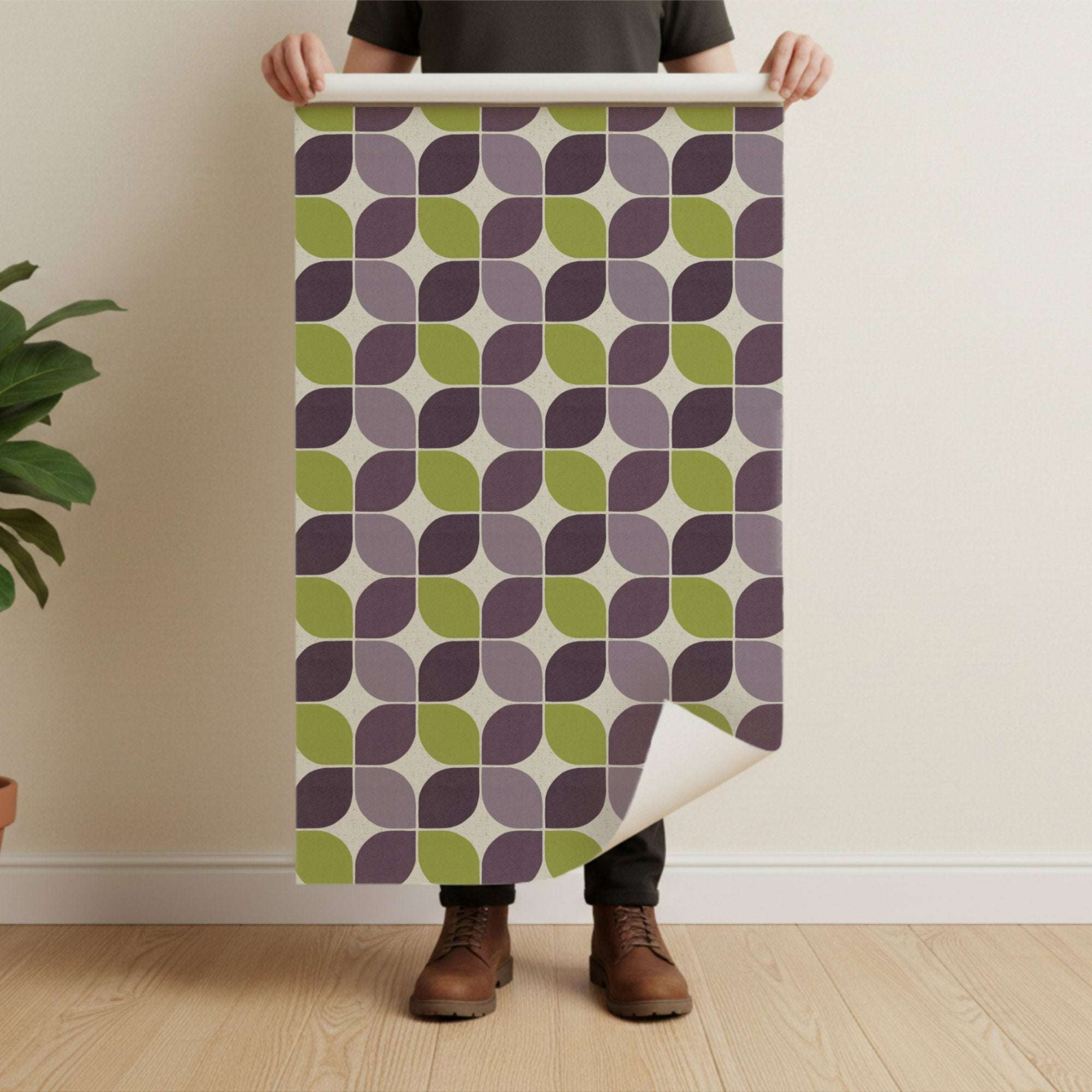 Geometric square wallpaper sheet held up; plum and green shapes on a light base