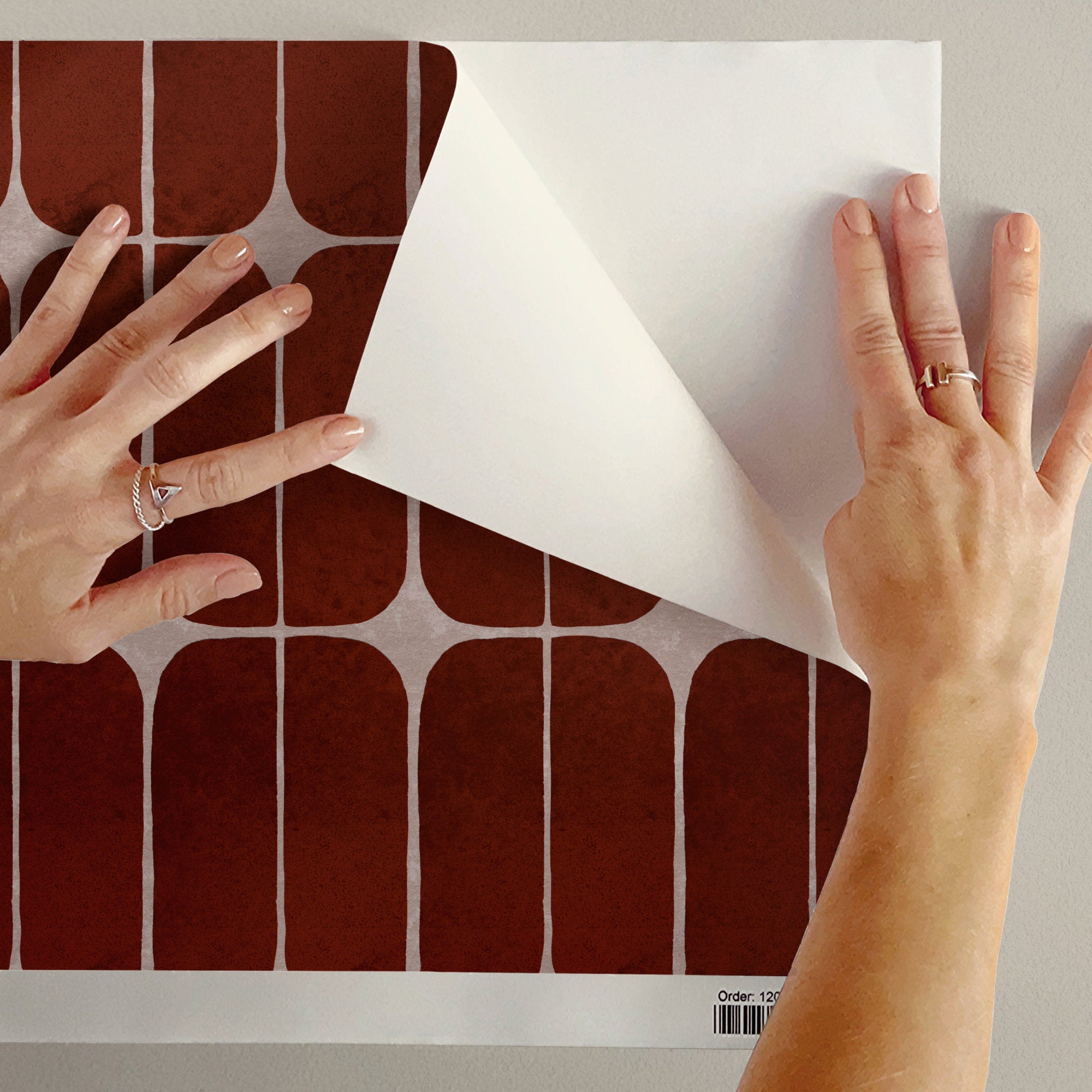 Peeling back terracotta retro tile wallpaper to show the removable peel and stick finish