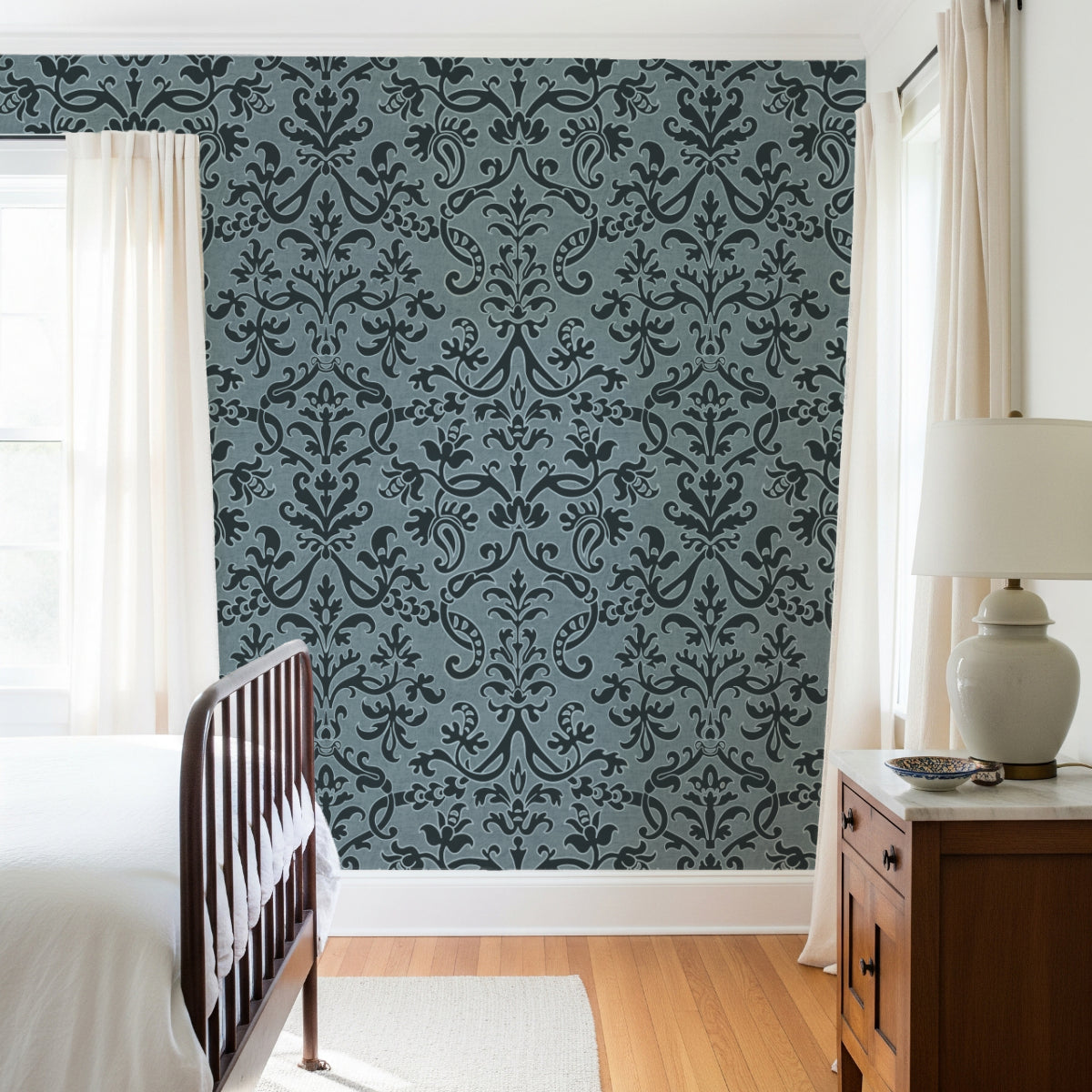 Bright bedroom with Victorian damask wallpaper in dark blue, white curtains, and modern decor.
