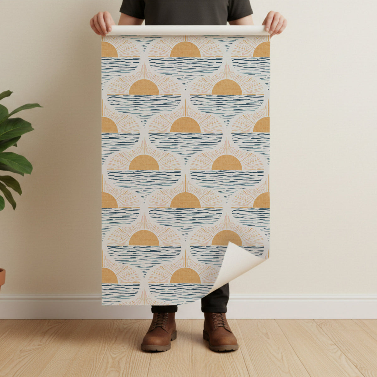 man holding a peel and stick wallpaper roll featuring boho coastal sunise pattern