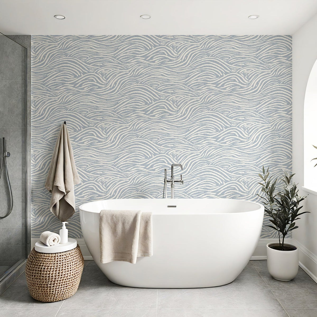 light airy bathroom with a white bath tub and coastal waves wallpaper pattern on the wall