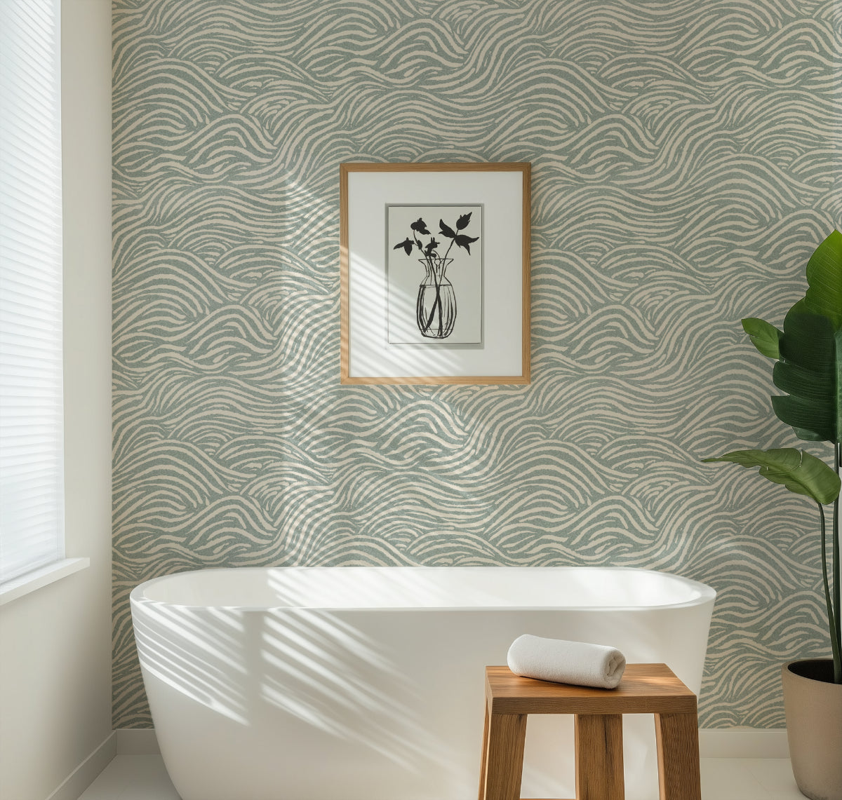 Bathroom with a green coastal waves patterned wallpaper, white freestanding bathtub, wooden stool, and plant.