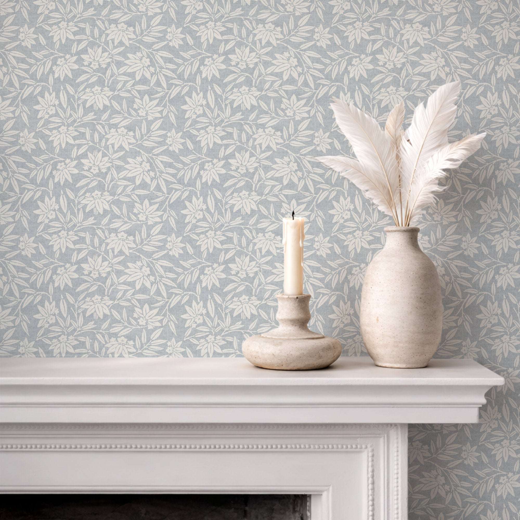 Botanical wallpaper on wall with repeating cream leaf sprigs on cool blue-gray background