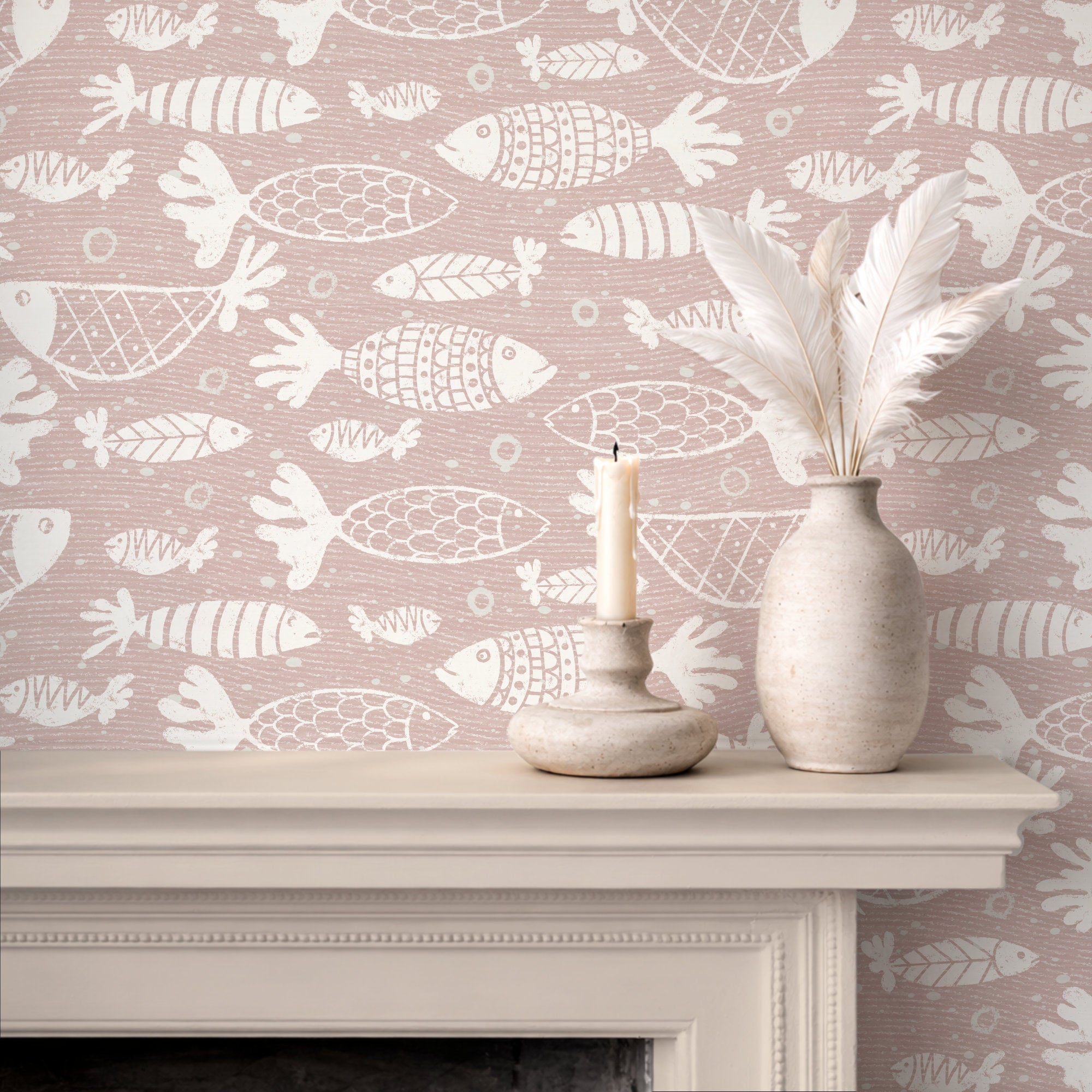 A styled interior scene showing a fireplace mantel with patterned pink and white school of fish wallpaper, a white feather vase, and a candle holder with a lit candle.