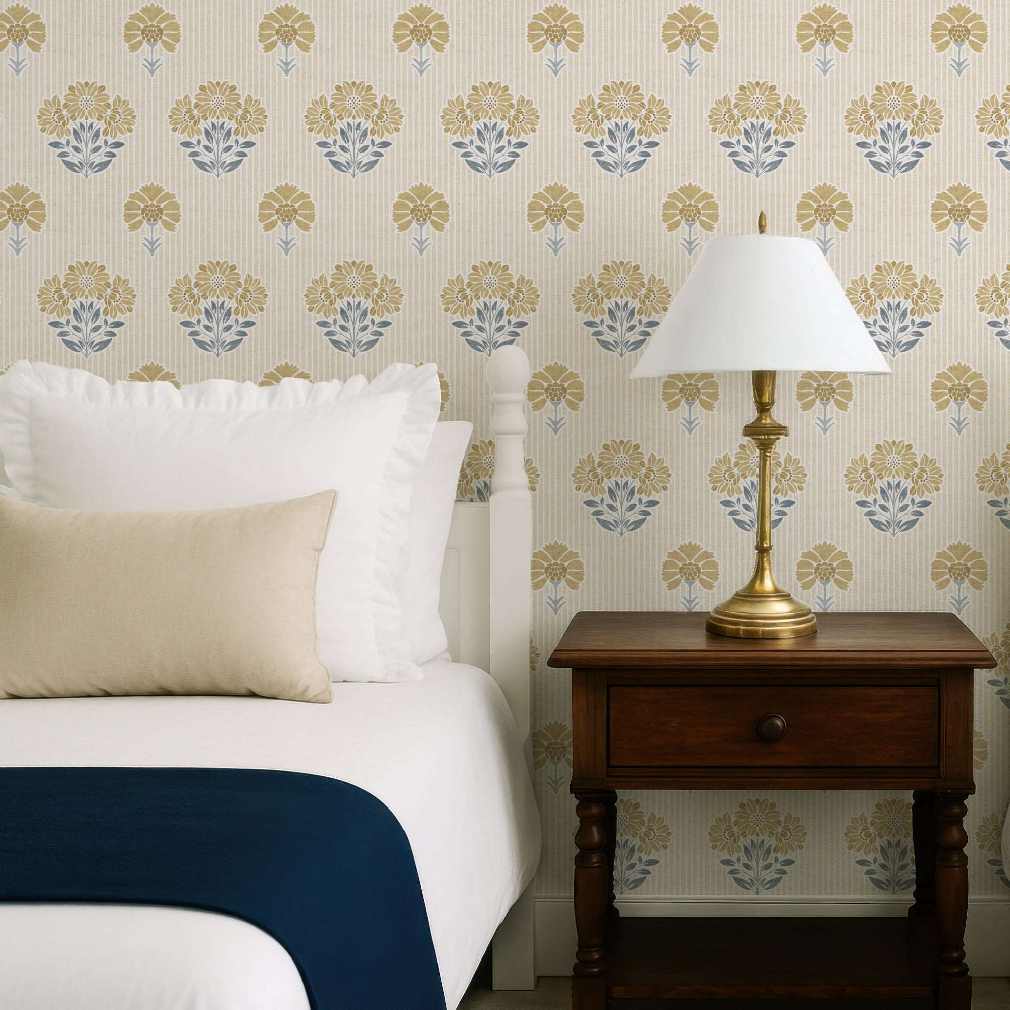 Floral wallpaper on wall with repeating yellow and blue flower heads and leafy stems