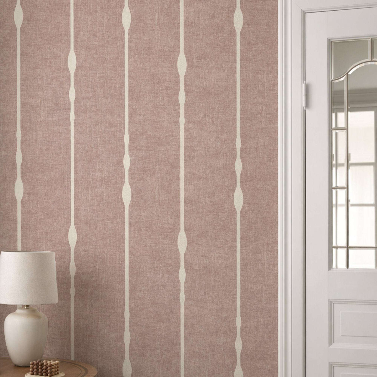 Vertical striped wallpaper with beaded stripe motif on dusty pink ground and pale vertical lines