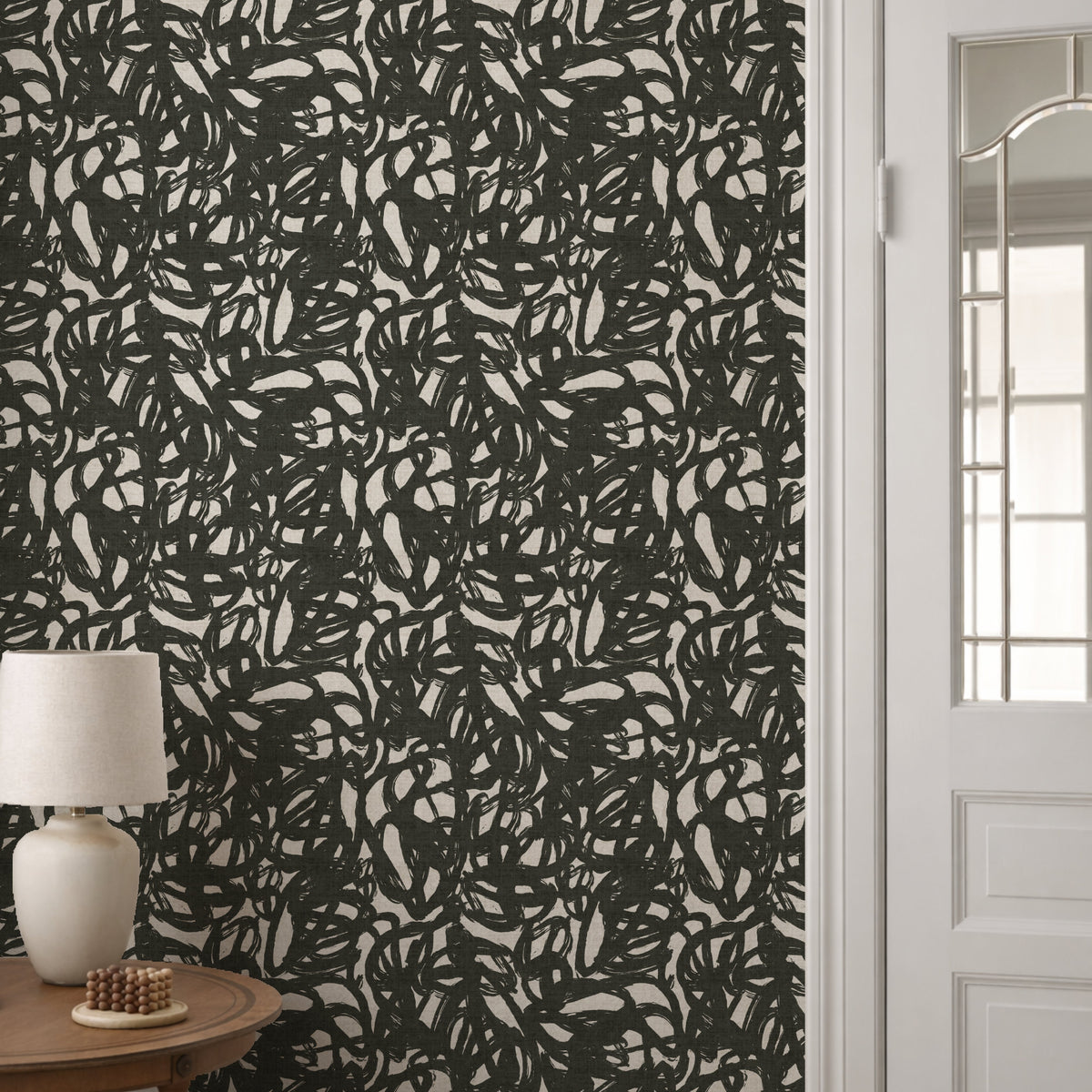 Black and white squiggle wallpaper roll showing bold abstract brushstroke pattern