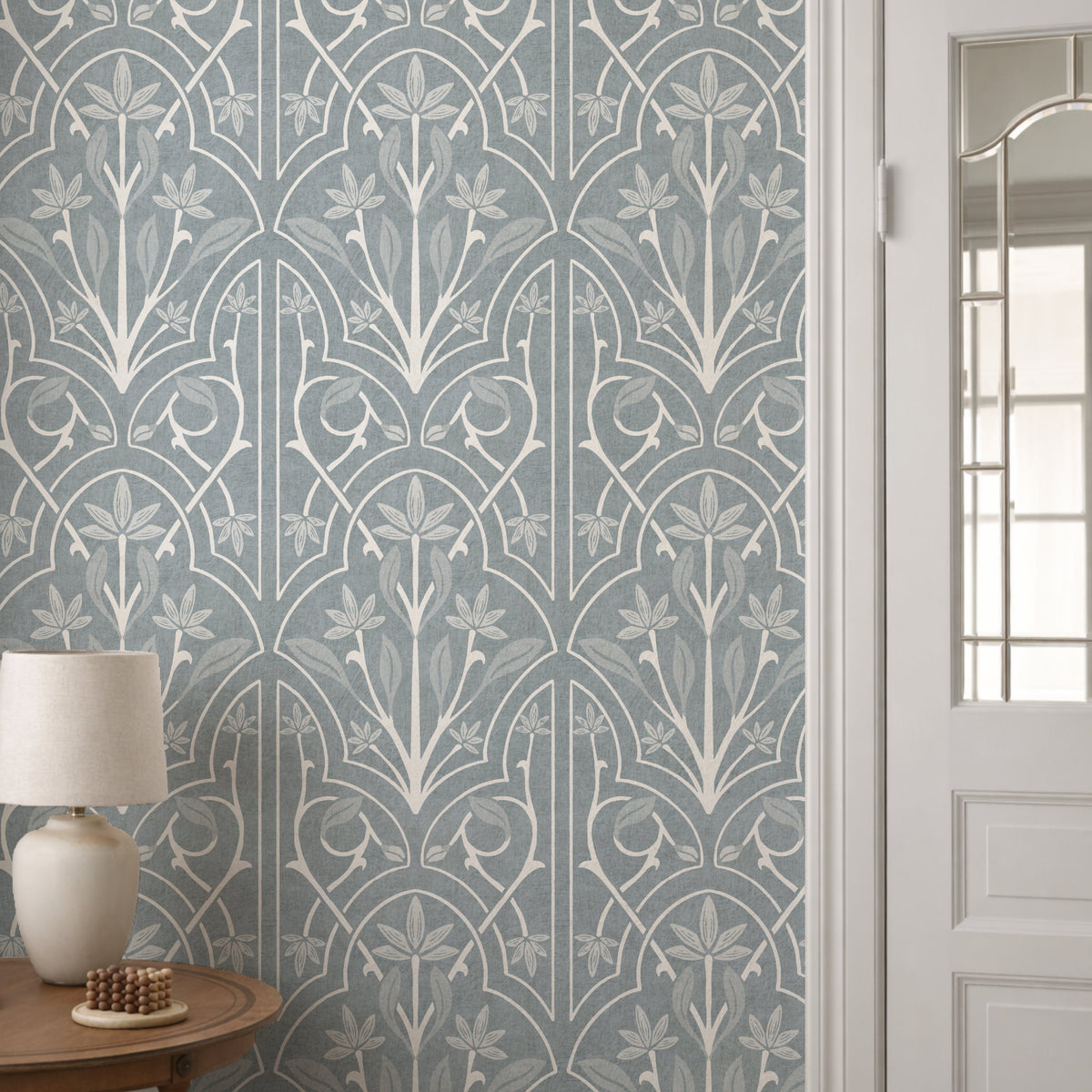 Floral trellis wallpaper in duck egg blue in hallway with white door and lamp 