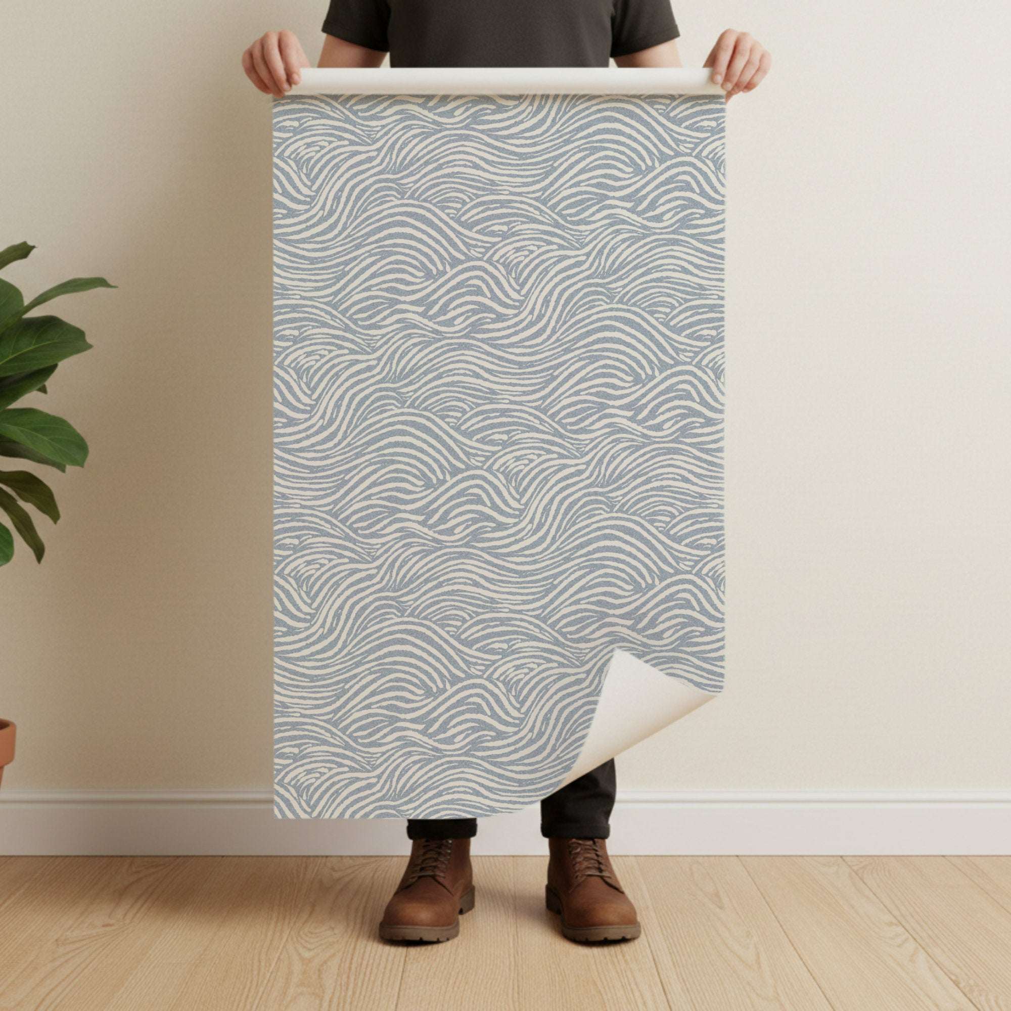 Wave-pattern wallpaper sample with light blue wavy lines on a pale beige sheet