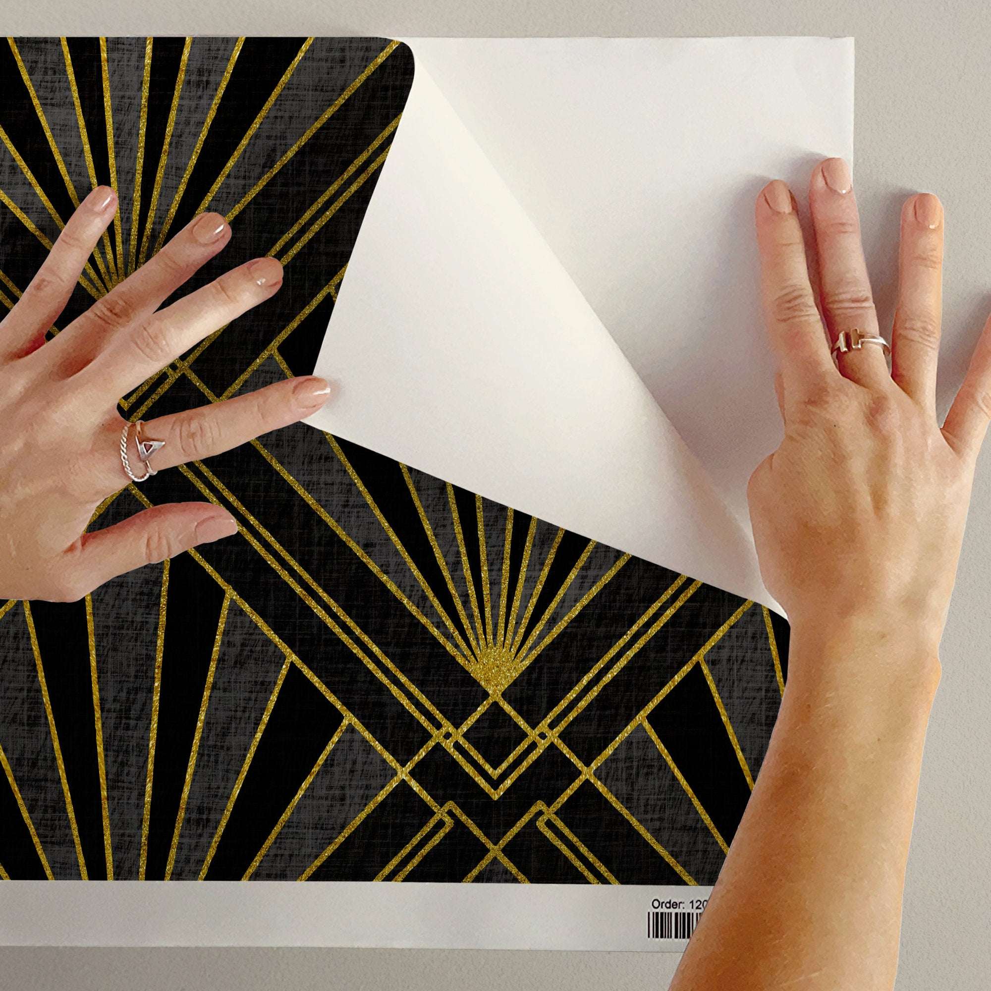 Wallpaper sample sheet with gold art deco sunburst and diamond lattice pattern on dark background