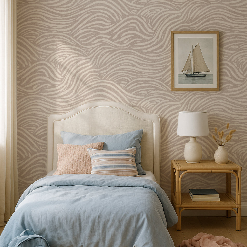 Bedroom with sandy beige coastal waves  patterned wallpaper, bed with colorful pillows, and a nightstand with a lamp.