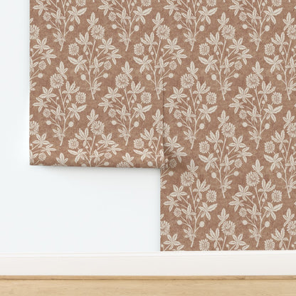 Close-up wall view of tan block print wallpaper with repeating floral and geometric diamond design.