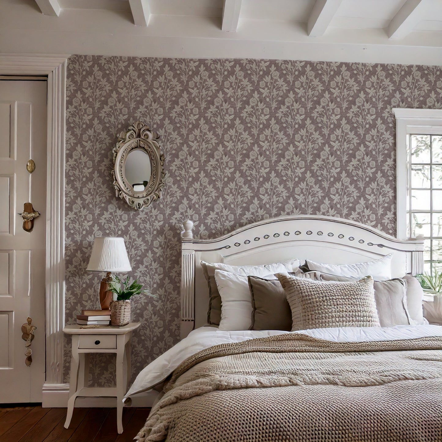 Cottage-style bedroom with ceiling beams and burgundy block print wallpaper featuring floral and geometric pattern.