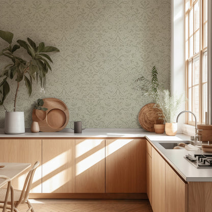 Light Green Victorian damask floral wallpaper in a light-filled kitchen with wooden cabinets and large window.