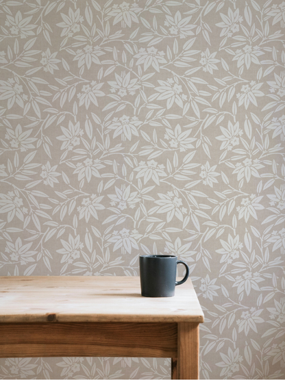 Light-filled dining room with a wooden table against taupe Japandi botanical wallpaper featuring stylised lotus leaves