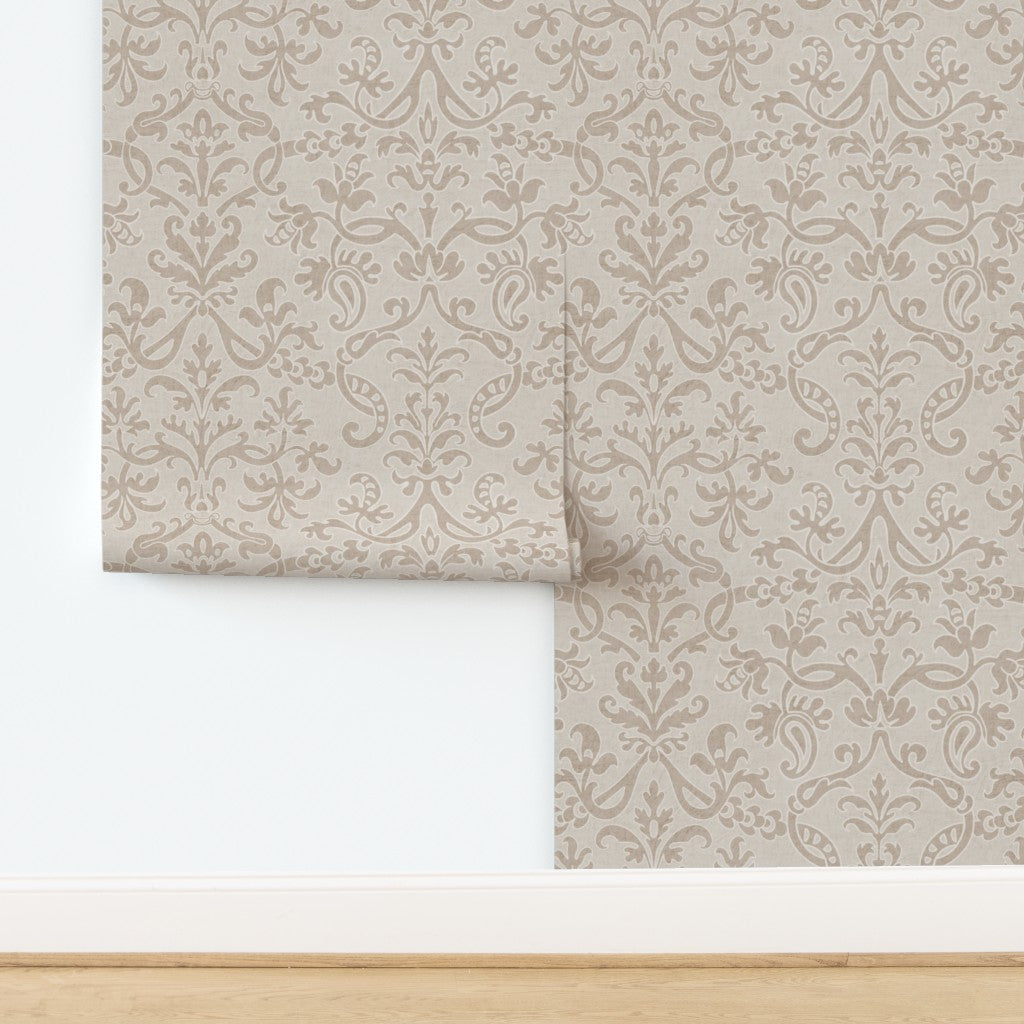 Close-up of neutral Victorian damask floral wallpaper roll showing intricate floral pattern.
