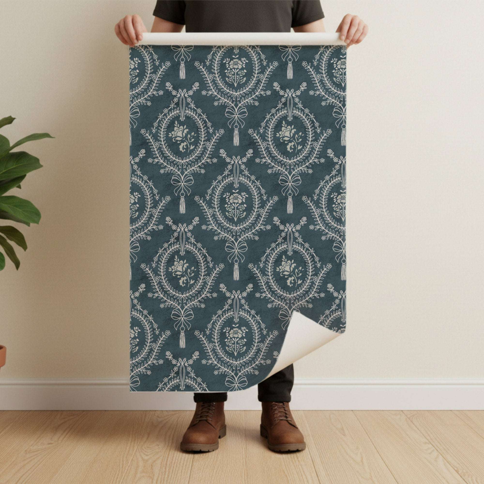 Teal wallpaper sheet showing repeating floral medallions, bows, and tassels.