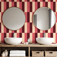 Wide block stripe wallpaper in burgundy and blush pink in bathroom with round mirrors and white basins