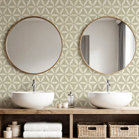 Light green geometric wallpaper in bathroom with double basins and round gold mirrors