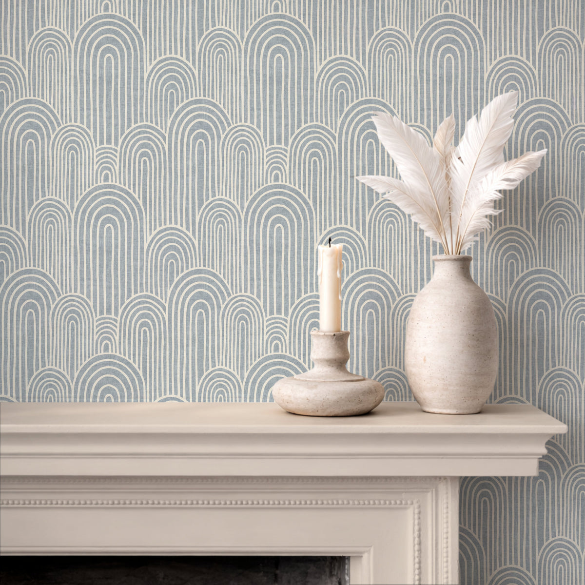 Light blue arches wallpaper above fireplace with candle and ceramic vase