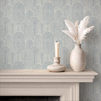 Light blue arches wallpaper above fireplace with candle and ceramic vase