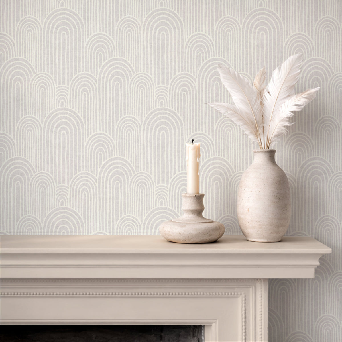 Neutral arches wallpaper above fireplace with candle and ceramic vase