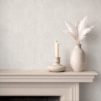 Neutral arches wallpaper above fireplace with candle and ceramic vase