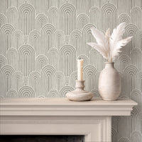 Stone grey arches wallpaper above fireplace with candle and ceramic vase