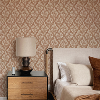 Bedroom with black lamp and tan block print wallpaper in a floral geometric diamond design.