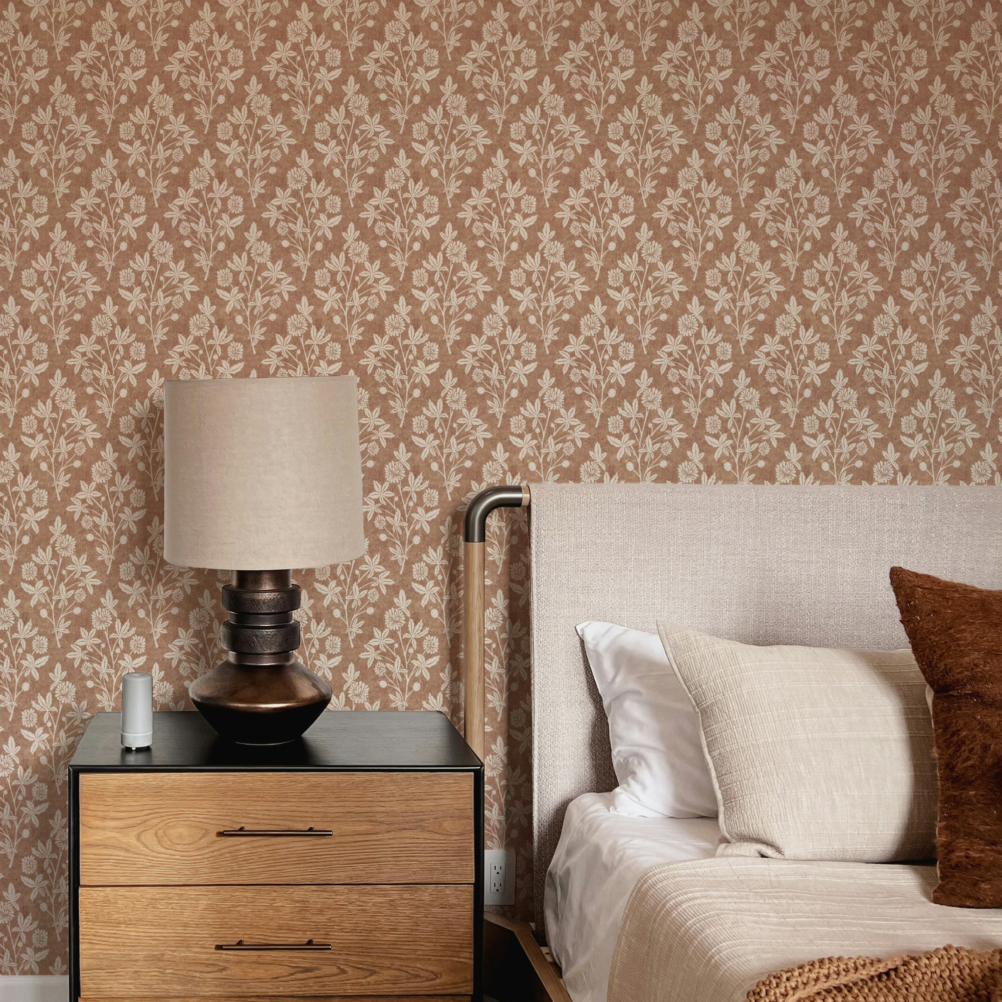 Bedroom with black lamp and tan block print wallpaper in a floral geometric diamond design.