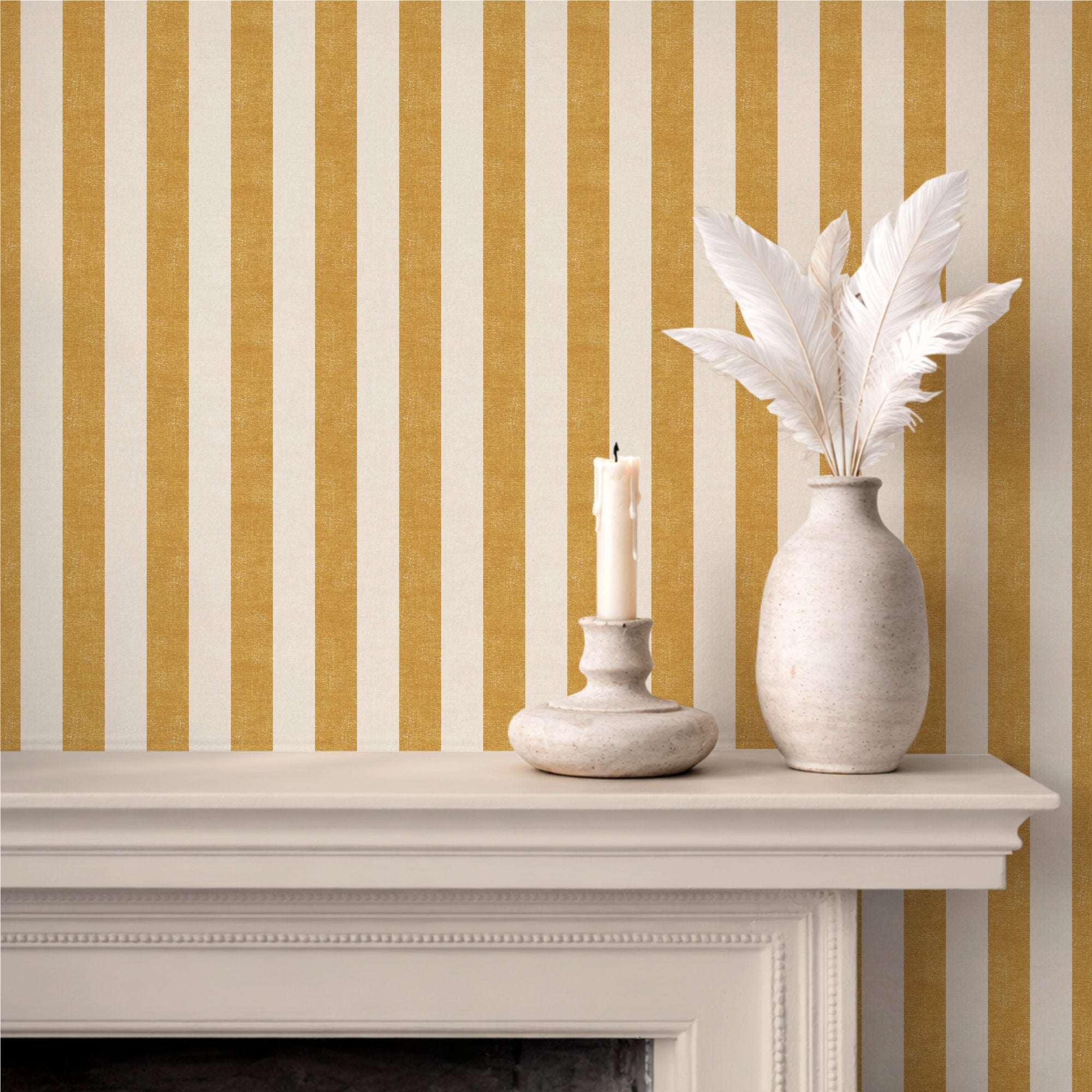 Bold wide stripe wallpaper in ochre yellow, styled with a fireplace mantel, ceramic vase and candle, warm boho living room