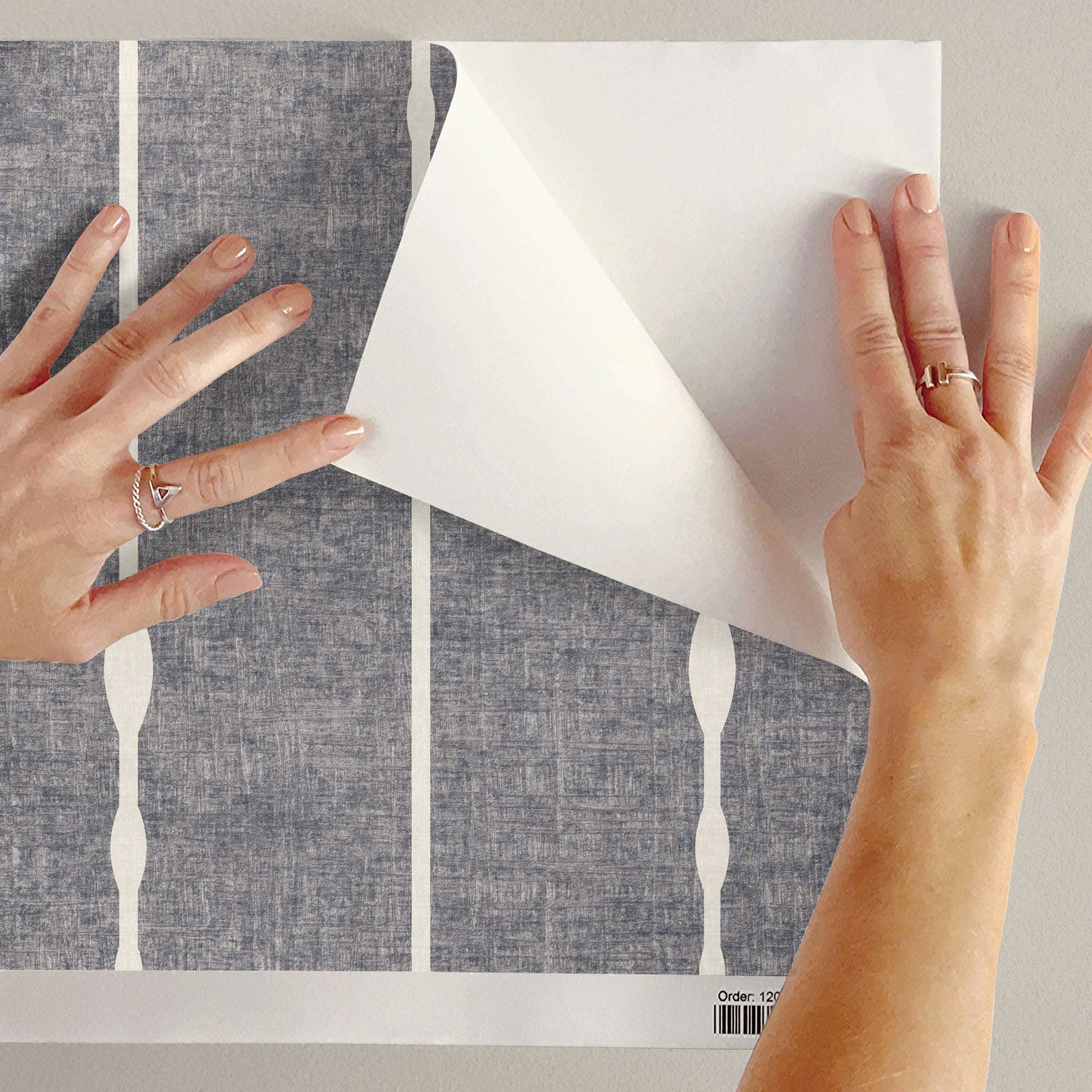 Vertical striped wallpaper roll showing beaded vertical stripes on gray ground with light columns