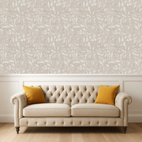 Beige tufted sofa with yellow cushions against an abstrasct brushstroke patterned wall.