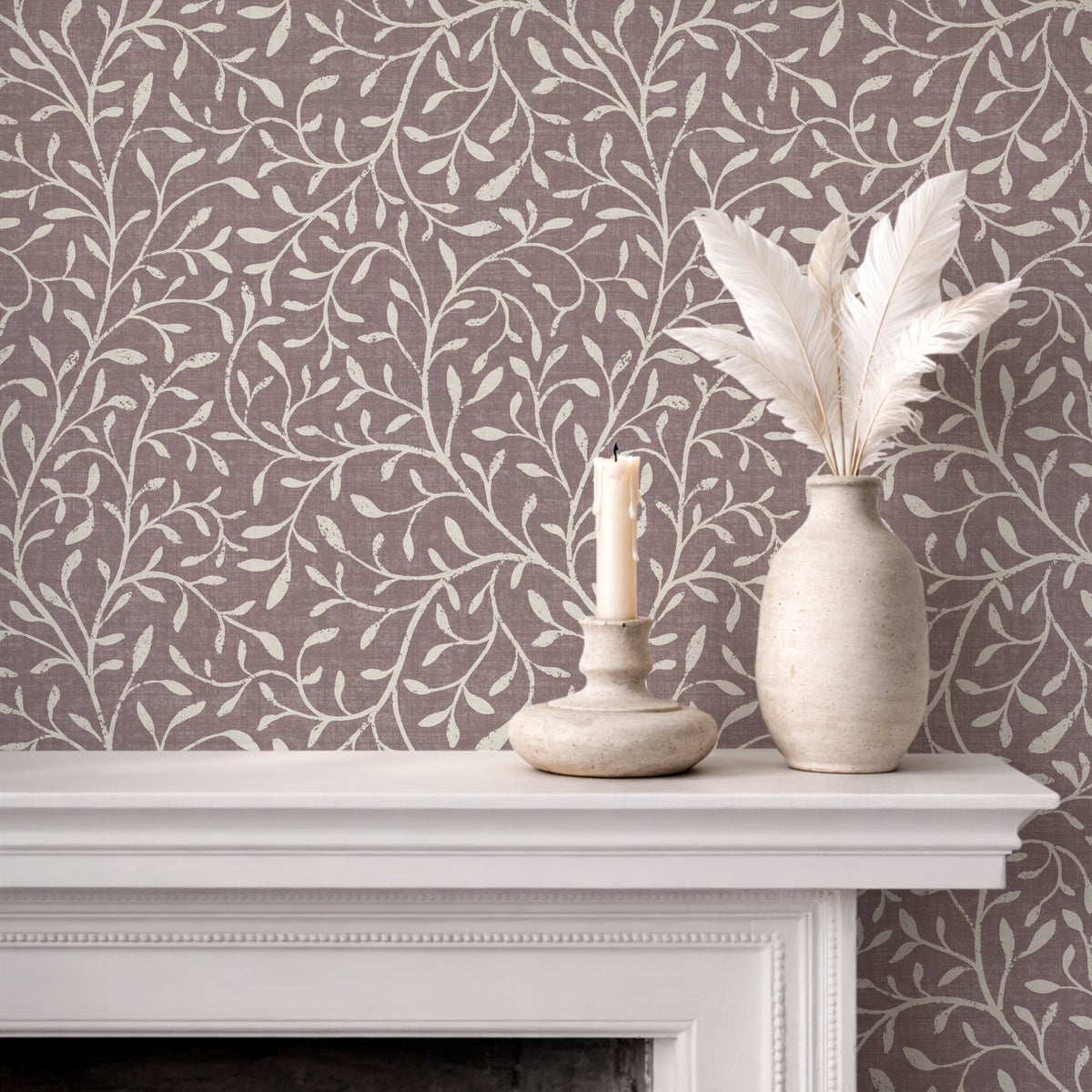Botanical leaf silhouette wallpaper in muted burgundy on fireplace mantel with white vases
