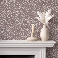 Botanical leaf silhouette wallpaper in muted burgundy on fireplace mantel with white vases